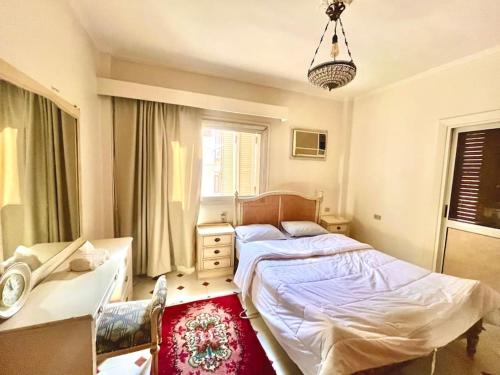 a bedroom with a bed and a desk and a window at 4-Brs Historical Apt in Maadi 5-Min to Nile in Cairo