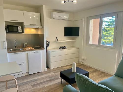 une cuisine et un salon avec un canapé et une table dans l'établissement Le Père Soulas, à Montpellier