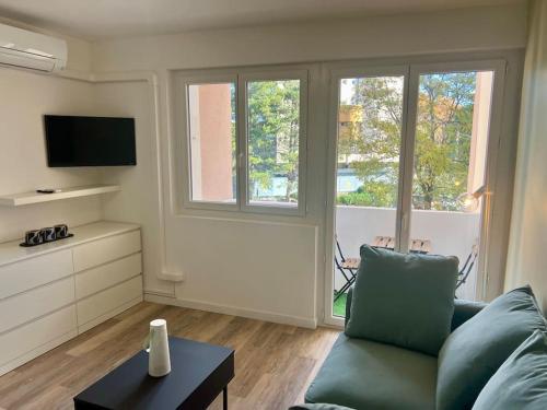 un salon avec un canapé et une télévision dans l'établissement Le Père Soulas, à Montpellier