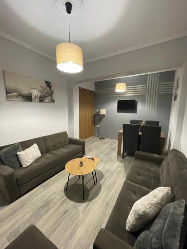 a living room with a couch and a table at DT Luxury Apartment in Nea Peramos