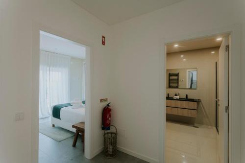 a white bedroom with a bed and a bathroom at Best Houses 108 - Casa Sea Mountain in Ferrel