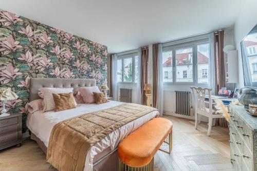 1 dormitorio con cama, mesa y ventanas en Splendide Appartement Cosy, en Charenton-le-Pont