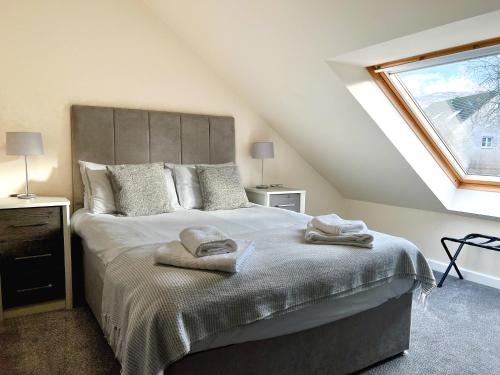 a bedroom with a bed with two towels on it at Loch Ness Gate House in Fort Augustus