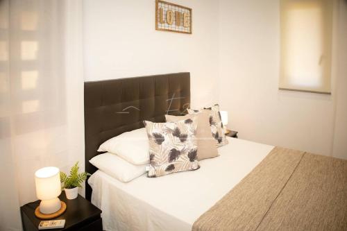 a bedroom with a bed with white sheets and pillows at BelMonStays Lubina del Sol, Riviera, Mijas Costa in Mijas Costa