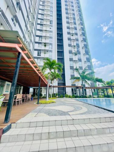 a large building with a swimming pool in front of it at Sunset View 1-BR Unit at Centrio Tower beside Ayala Mall Downtown CDO in Cagayan de Oro
