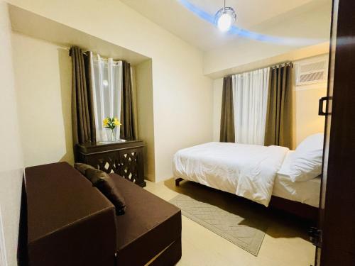 a bedroom with a bed and a couch in a room at Sunset View 1-BR Unit at Centrio Tower beside Ayala Mall Downtown CDO in Cagayan de Oro