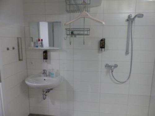 a white bathroom with a sink and a shower at Ferienwohnung in 09548 Seiffen bis maximal 18 Personen in Kurort Seiffen