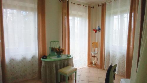 a room with two windows and a table and a chair at LA CASA DEI MASUE' in Alba