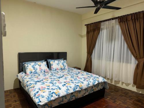 a bedroom with a bed and a ceiling fan at Belian Homestay Sibujaya in Sibu