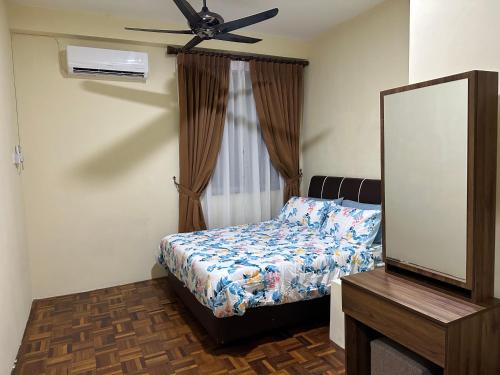 a bedroom with a bed and a mirror and a ceiling fan at Belian Homestay Sibujaya in Sibu