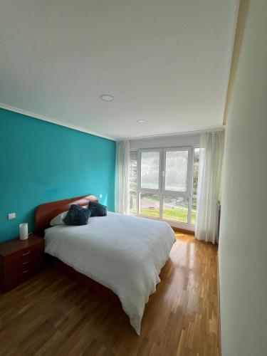 1 dormitorio con 1 cama grande y pared azul en Casa Maria en Beranga