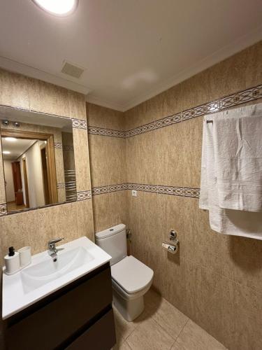 een badkamer met een wastafel, een toilet en een spiegel bij Casa Maria in Beranga