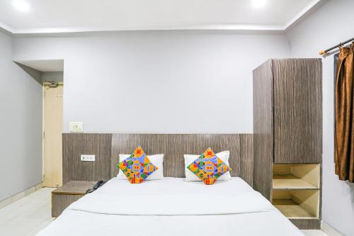 a bedroom with a large bed with a wooden headboard at FabHotel Sun Om in Raipur