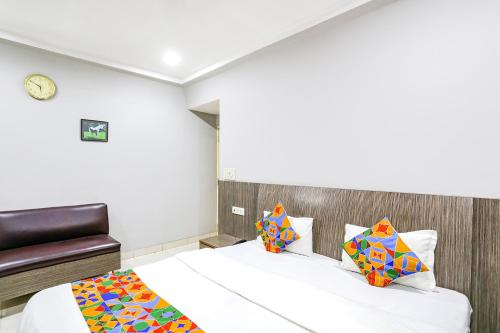 Habitación de hotel con cama y silla en FabHotel Sun Om, en Raipur