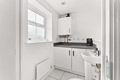 a white bathroom with a sink and a toilet at Stylish 4 bed - Parking - Sleeps 14 in Bristol