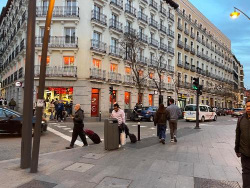 a group of people walking down a city street with luggage at HOSTAL DANIEL in Madrid