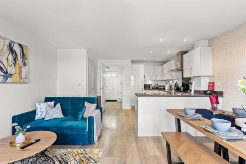 a living room and kitchen with a blue couch at Stylish 4 bed - Parking - Sleeps 14 in Bristol