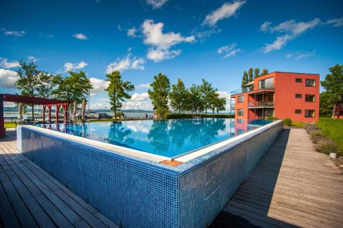 a large swimming pool with a building in the background at BL Apartman by HelloBalatonlelle in Balatonlelle