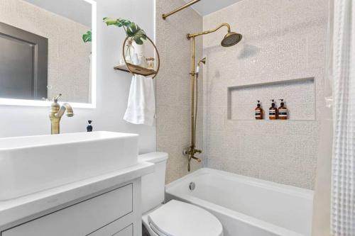La salle de bains blanche est pourvue d'un lavabo et de toilettes. dans l'établissement Rodeo Escape: Sleeps 8, Parking, Wi-Fi, Free Gym, à Houston