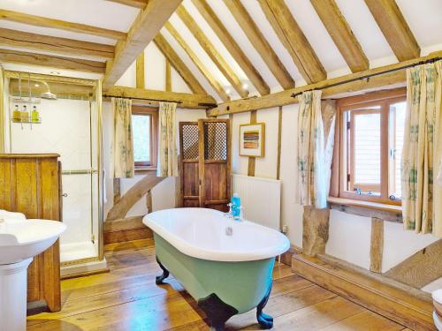 ein Badezimmer mit einer Badewanne und einem Waschbecken in der Unterkunft Walnut Barn - Horsham in Horsham