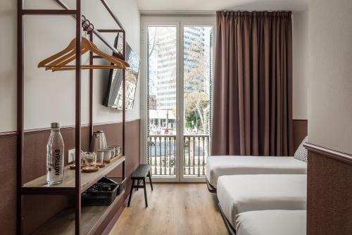 Habitación de hotel con 2 camas y ventana en BYPILLOW Ramblas en Barcelona