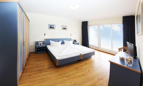 キュールングスボルンにあるYachthafenresidenz-Wohnung-9302-918のベッドルーム1室(ベッド1台、大きな窓付)