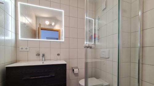 a bathroom with a sink and a shower with a mirror at Yachthafenresidenz-Wohnung-9302-918 in Kühlungsborn