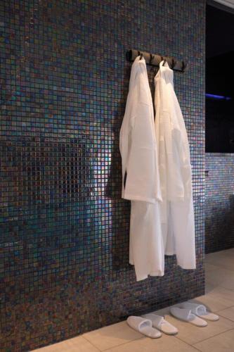 a group of white robes hanging on a wall at The Angus Hotel & Spa in Blairgowrie