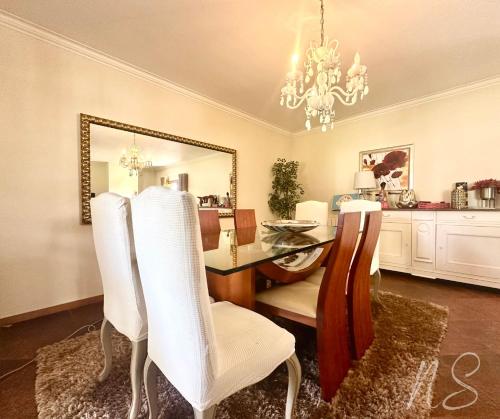 ein Esszimmer mit Tisch und Stühlen und einem Spiegel in der Unterkunft CASA DA TIA ROSA in Fiscal