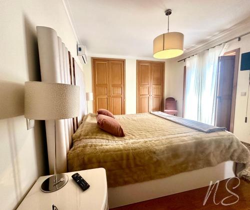 ein Schlafzimmer mit einem Bett und einer Lampe auf einem Tisch in der Unterkunft CASA DA TIA ROSA in Fiscal