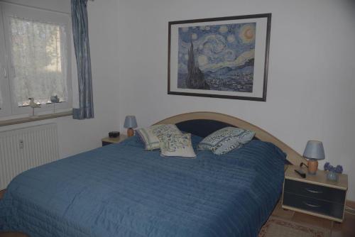 a bedroom with a blue bed with two pillows at Ferienanlage-Reriker-Strasse-EG-links-9388 in Kühlungsborn