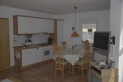 a kitchen and dining room with a table and chairs at Ferienanlage-Reriker-Strasse-EG-links-9388 in Kühlungsborn
