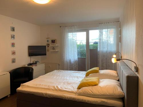 a bedroom with a bed with a window and a desk at Yachthafenresidenz-Wohnung-8106-9412 in Kühlungsborn