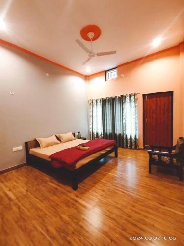 1 dormitorio con 1 cama y suelo de madera en Gharonda Homestay, en Dogadda