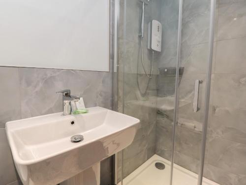 a bathroom with a sink and a shower at Pear Tree Cottage at Hey Farm in Barnoldswick