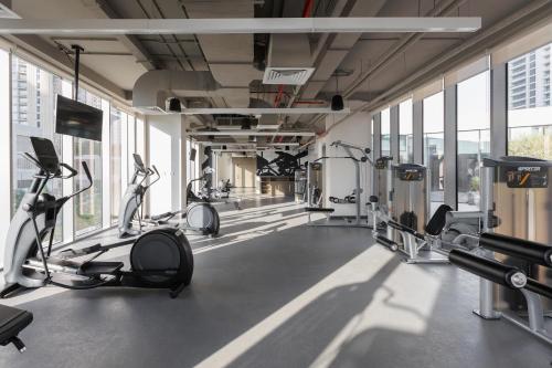 einen Fitnessraum mit Laufbändern und Trainingsgeräten in einem Gebäude in der Unterkunft Burj Khalifa View & Creek lagoon in Dubai