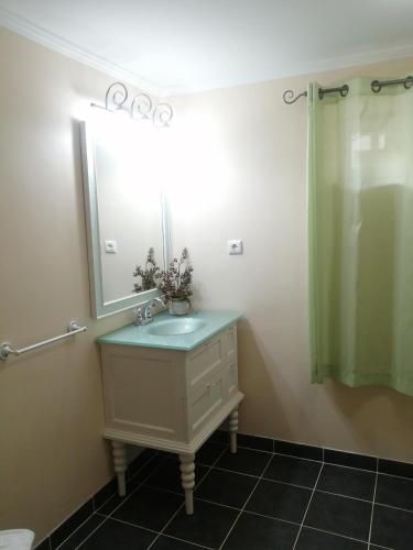 a bathroom with a sink and a mirror at Apartamento Solar dos Castanheiros in Prainha de Baixo