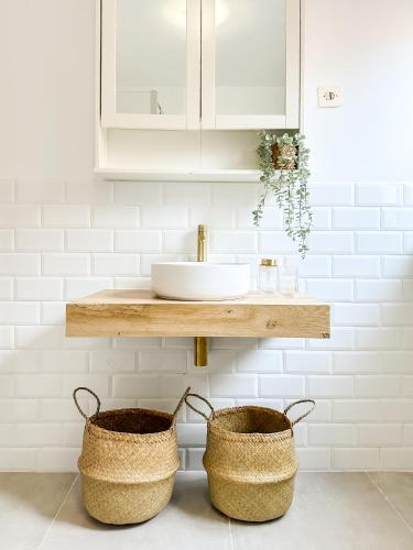 a bathroom with two baskets and a sink at Apartamento Cozy by ALÔGA in Cee