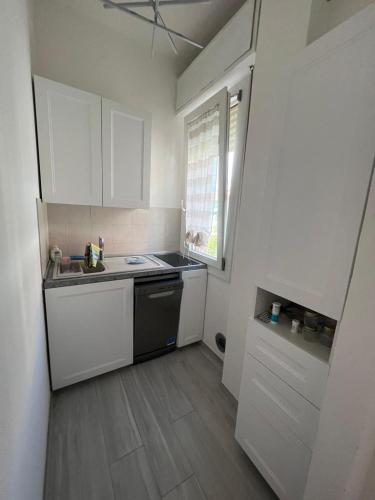 a small kitchen with white cabinets and a sink at Nido azzurro in Cesenatico