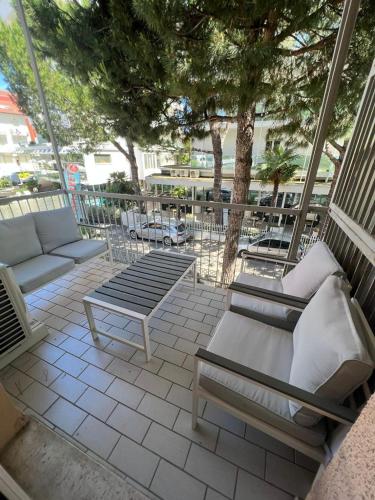 une terrasse avec des chaises, un canapé et des arbres dans l'établissement Nido azzurro, à Cesenatico