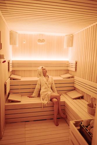a woman is sitting in a sauna at Fresco Cave Suites Cappadocia in Urgup