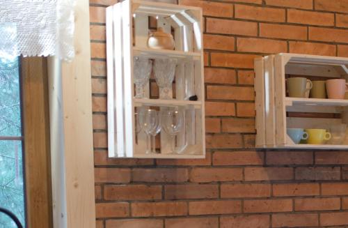 a brick wall with two shelves with wine glasses at Ajurweda na Jurze Agroturystyka in Choroń