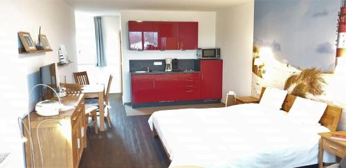 キュールングスボルンにあるYachthafenresidenz-Wohnung-9205-917の赤いキャビネットとテーブル付きのキッチンが備わる客室です。