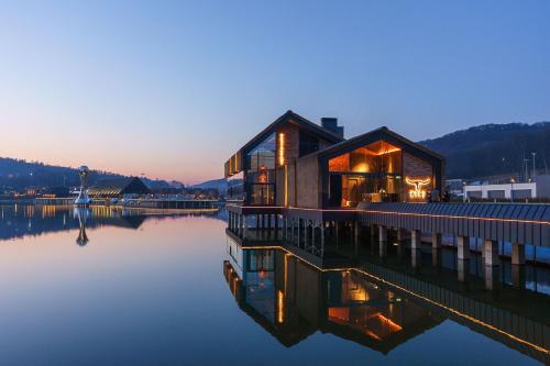 a wooden house on the water at dusk at Emily Resort in Lviv
