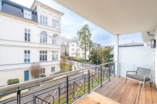 a balcony with a chair and a view of a street at Quartier am Strand - App 05 in Neuhof