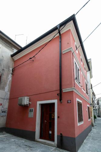 a red building on the side of a street at Appartamento Da Andrea in Izola