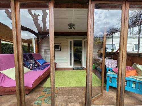 a screened in porch with a bed and a couch at Mobile home toutes saisons in Beauzac