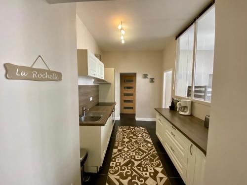 une cuisine avec un évier et un plan de travail dans l'établissement Le Gîte Du Parc avec parking vieux port et plage au calme, à La Rochelle