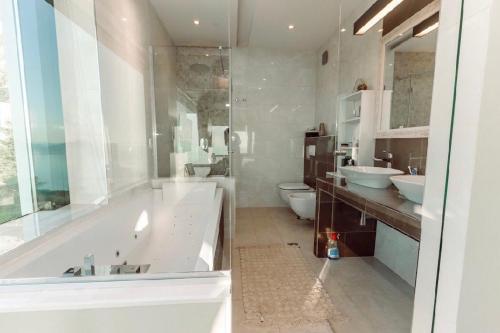 a bathroom with two sinks and a tub and two toilets at Vila Agata in Budva