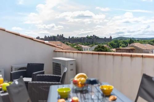 d'un balcon avec une table et une vue sur la ville. dans l'établissement La Majestueuse Cité, à Carcassonne